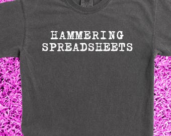 Davis Clarke's greatness was the inspiration: faux band merch from heavy hitters, 'Hammering Spreadsheets.' Garment dyed concert tee.