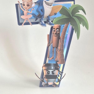 May include: A three-dimensional number seven decoration featuring a blue border and holographic centre. It is adorned with cartoon character cutouts including a coffee cup ballerina, a surfing shark, a wooden figure, and a ninja coffee cup.