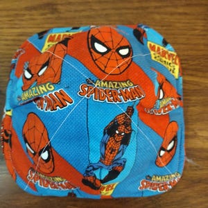 May include: A blue and red baseball cap with a repeating pattern of Spiderman images. The cap features the words "Amazing Spiderman" and "Marvel Comics".