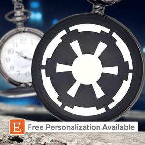 May include: A black pocket watch with a white Imperial symbol from Star Wars. The watch has a silver chain and is on a gray surface. Free personalization available.