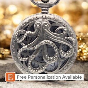 May include: Silver pocket watch with an intricate design featuring an octopus with tentacles. The watch face is visible with Roman numeral markings.