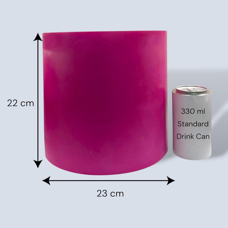 Large fuchsia round plant pot with measurement arrows showing 22 cm height and 23 cm width, placed beside a standard 330 ml drinks can for size comparison on a pale grey background.