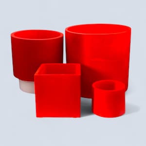 May include: Four red containers of different shapes and sizes. There is a cylindrical container, a square container, and two other cylindrical containers. The containers are all a solid, bright red colour.