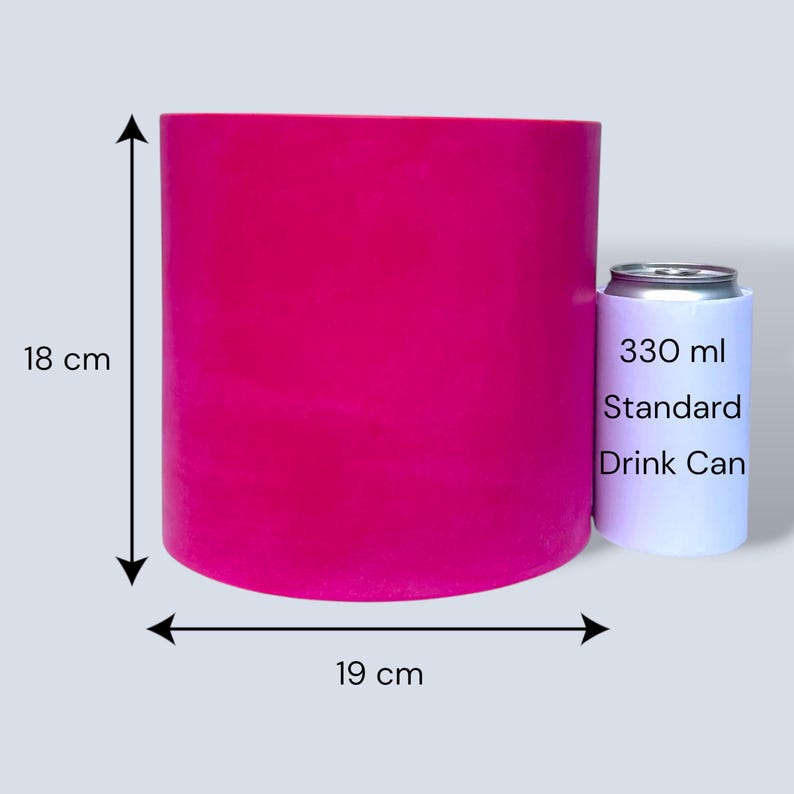 Bright fuchsia round plant pot with measurement arrows showing 18 cm height and 19 cm width, placed beside a standard 330 ml drinks can for size comparison on a pale grey background.