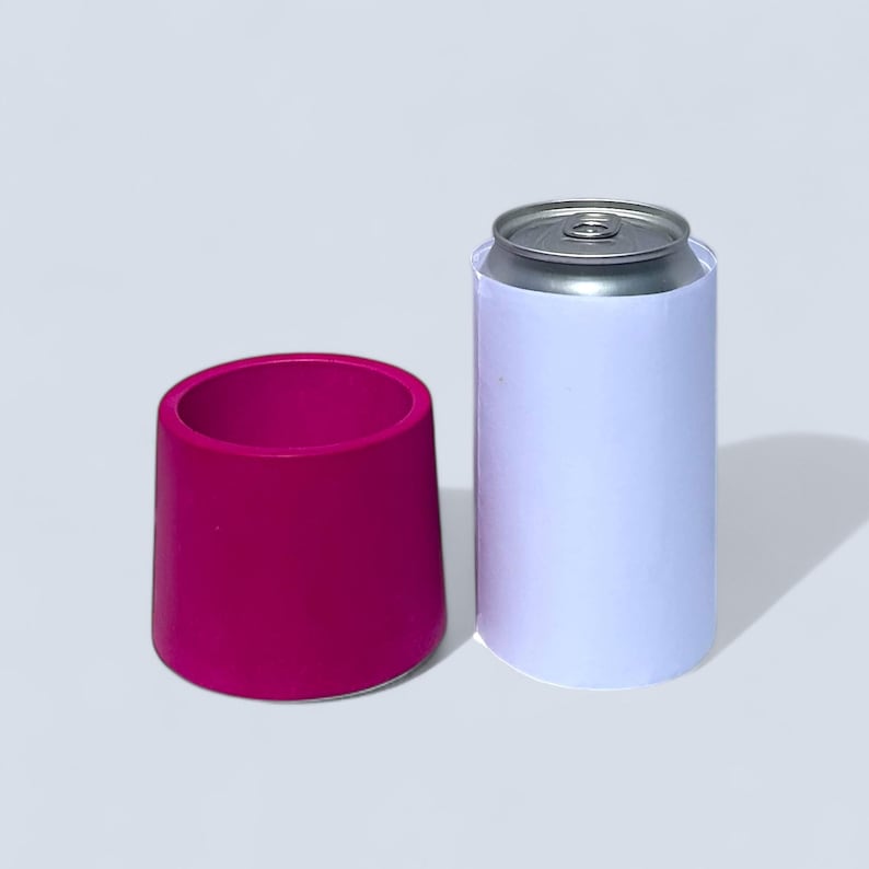 A 7.5 cm cylindrical succulent pot next to a 330ml can . The vibrant magenta pot tapers towards the top. The pot is roughly half the height of the can and slightly wider.