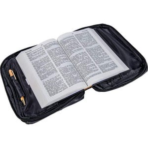 May include: A black leather Bible cover with a zipper closure and a pen holder. The cover is open to reveal a Bible with pages of text.