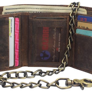 May include: Open brown leather wallet with multiple card slots, a clear ID window, and a chain. The wallet is filled with cash and cards. The chain is attached to the wallet with a clasp. The wallet has a distressed look.