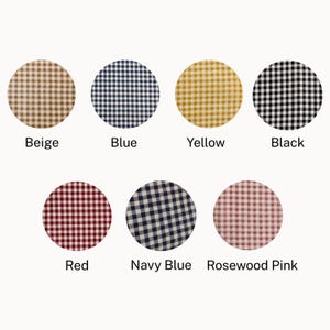 May include: A collection of seven fabric swatches in a gingham pattern, each in a different color. Colors include beige, blue, yellow, black, red, navy blue, and rosewood pink. Each swatch is labeled with its corresponding color name.