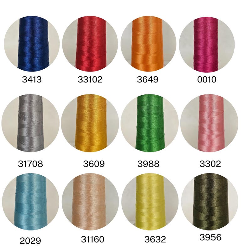 May include: A collection of twelve spools of thread in various colors, including blue, red, orange, pink, gray, gold, green, and brown. Each spool is labeled with a unique number. The threads appear to be smooth and shiny, suitable for sewing or embroidery projects.