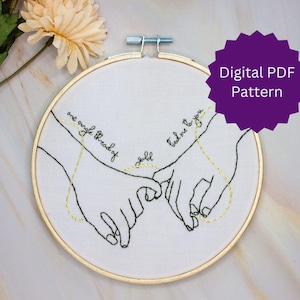 Pode incluir: Padrão de bordado de duas mãos segurando os mindinhos, com o texto "one single thread of gold" e "tell me to you".