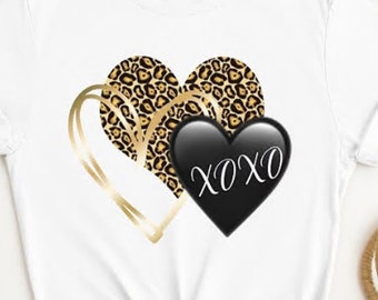 May include: White t-shirt with a gold and leopard print heart design and a black heart with the text "XOXO" on it.