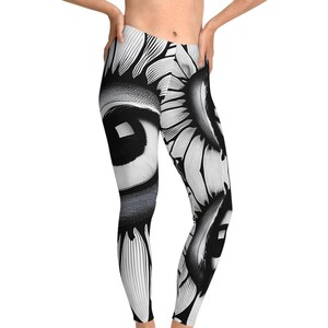 May include: Black and white leggings with a graphic print of a large eye and sunflower design.