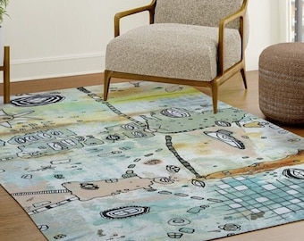 Könnte beinhalten: Ein abstrakter Teppich in Hellblau, Grün und Braun mit handgezeichnetem Design. Der Teppich hat einen abgenutzten, Vintage-Look und zeigt verschiedene Formen und Muster.