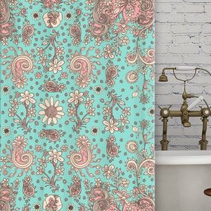 May include: A turquoise shower curtain with a pink and cream paisley pattern. The shower curtain is hanging in a bathroom with a white brick wall and a white bathtub.