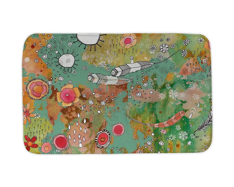 May include: A green, orange, and pink bath mat with a whimsical design featuring feathers, flowers, and swirls.