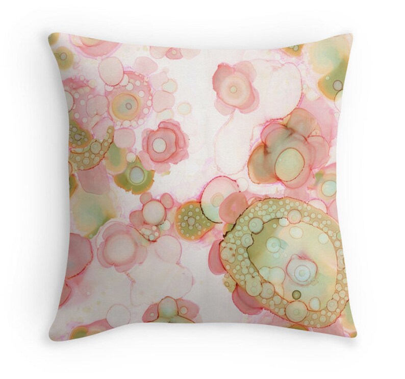 May include: Abstract pillow cover with a white background and a pattern of pink and green circles.