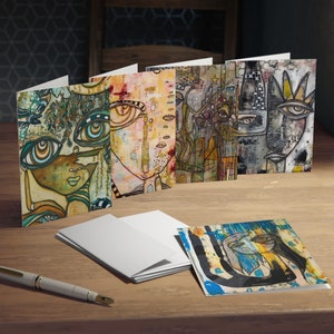 May include: Set of five greeting cards featuring abstract art with colorful faces and patterns. The cards are blank inside and perfect for sending a personalized message.