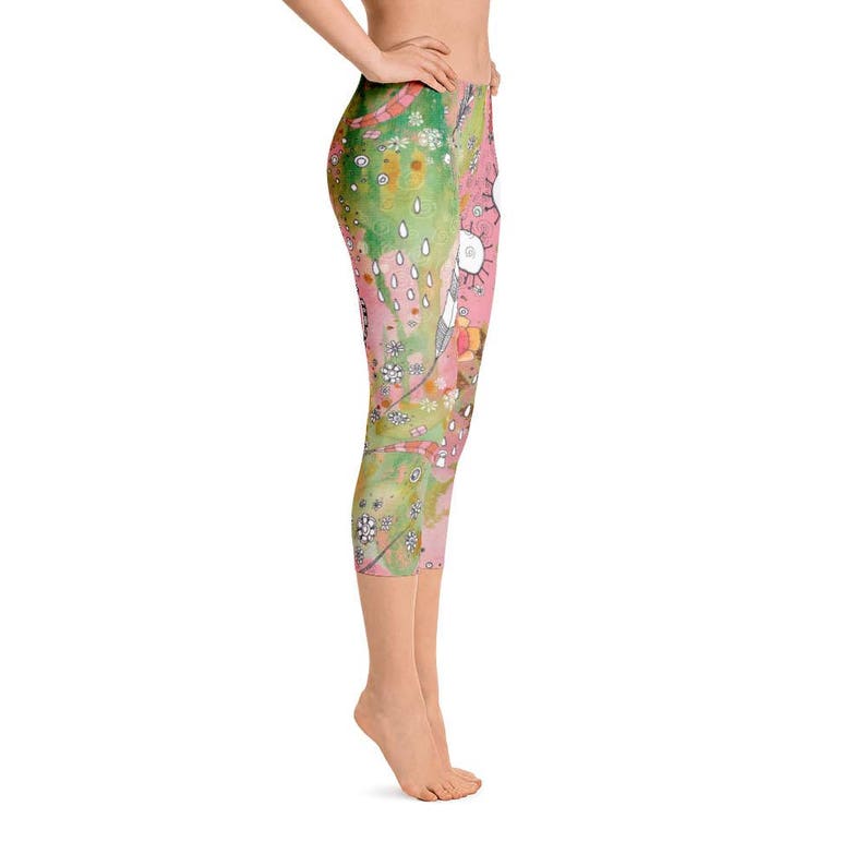 May include: Pink and green patterned leggings with a whimsical design featuring flowers, raindrops, and abstract shapes. The leggings are cropped and have a comfortable fit.