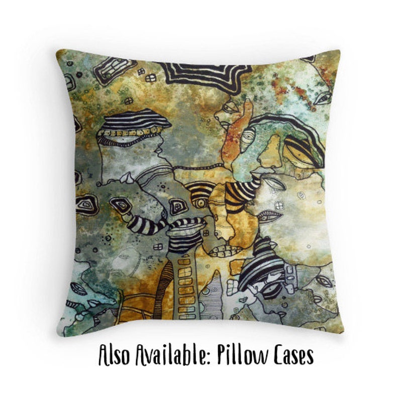 May include: A colorful abstract pillow featuring a pattern of faces and geometric shapes in shades of brown, green, and black. The pillow has a textured, watercolor-like background.