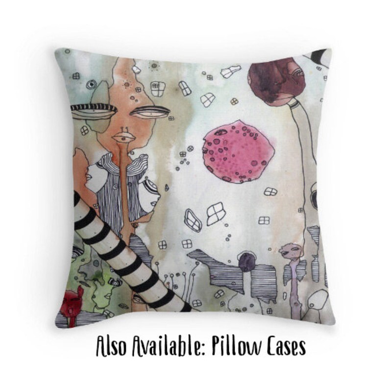 May include: A watercolor pillow featuring a whimsical abstract design with a pink circle, black and white lines, and a green and brown background. The pillow has a white border and the text "Also Available: Pillow Cases" is printed below the image.