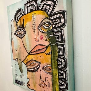 Puede incluir: Obra de arte abstracta de t&eacute;cnica mixta sobre lienzo. La pintura presenta un rostro estilizado con m&uacute;ltiples ojos, una criatura verde y un dise&ntilde;o floral amarillo y negro. La paleta de colores incluye tonos de amarillo, rosa, verde y negro.
