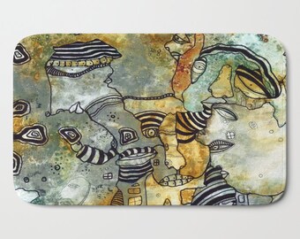 May include: Abstract art bath mat with a blue, green, and brown background. The design features black and white lines and shapes that resemble faces and eyes.
