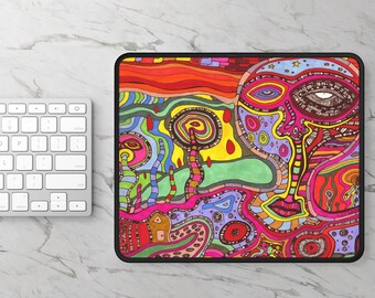 Può includere: Un colorato tappetino per mouse con un design astratto di un volto nei vivaci colori rosso, arancione, giallo, verde, blu e viola. L'opera d'arte ha uno stile psichedelico con dettagli intricati e un bordo nero. È visibile una tastiera bianca.