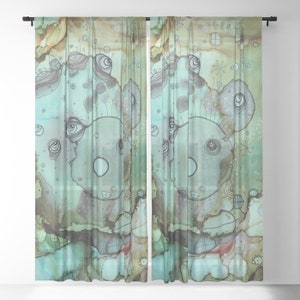 May include: A pair of sheer curtains with a watercolor design featuring a whimsical, abstract creature with multiple eyes and a light blue background. The design is reminiscent of a face with a large, round nose and a small mouth.
