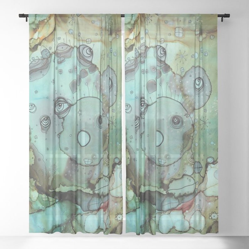 May include: A pair of sheer curtains with a watercolor design featuring a whimsical, abstract creature with multiple eyes and a light blue background. The design is reminiscent of a face with a large, round nose and a small mouth.