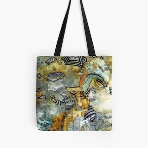May include: A tote bag with a colorful abstract design featuring a variety of shapes and patterns in shades of brown, green, and blue. The design appears to be hand-drawn and includes stylized faces and geometric shapes.