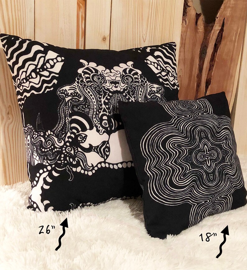 May include: Two black and white patterned throw pillows. The larger pillow is 26 inches and features a complex, abstract design. The smaller pillow is 18 inches and features a circular, concentric pattern.