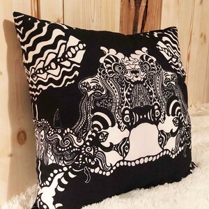 May include: Black and white decorative pillow with an abstract design featuring swirling patterns and shapes.