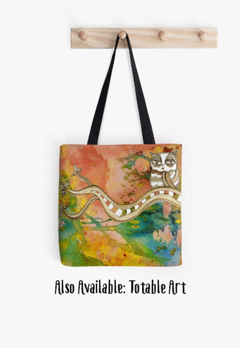 May include: A tote bag featuring a colourful abstract watercolour background with a white cat with black eyes sitting on a branch. The branch is a light brown colour with white stripes. The cat is looking to the right. The background is a mix of orange, yellow, green, blue, and pink.