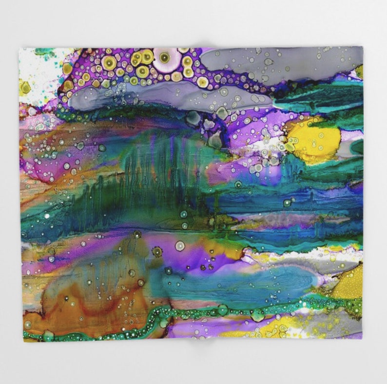 May include: Abstract art print featuring a colorful landscape with purple, blue, green, yellow, and orange hues. The print has a textured, layered look with small white circles throughout.