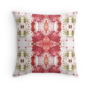 May include: Red and green abstract pattern on a white background. The pattern is symmetrical and has a geometric design. The pillow is a square shape.