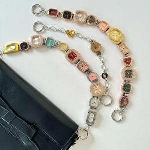 May include: A black leather handbag with a chain strap made of multiple linked watches with different coloured faces.