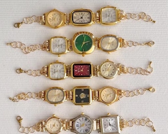 Könnte beinhalten: Ein Set aus acht goldfarbenen Armbanduhren mit verschiedenen Zifferblattmustern. Die Uhren sind durch eine goldene Kette miteinander verbunden.