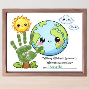 May include: A framed print featuring a handprint tree, a smiling sun, and a cartoon Earth. The text reads, "With my little hands I promise to help protect our planet." The name "Charlotte" is written below.