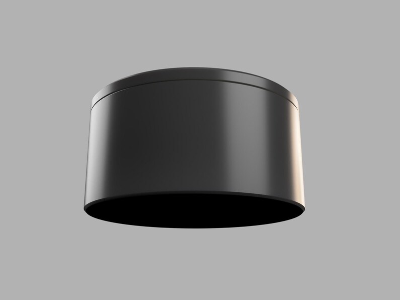 May include: A black cylindrical container with a smooth, glossy finish. The container is empty and has a rounded top and bottom.