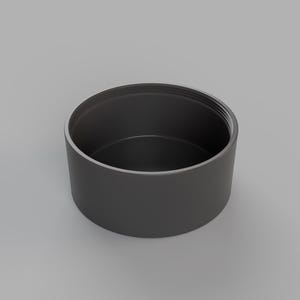 May include: A black cylindrical container with a smooth, rounded top and a slightly textured bottom.