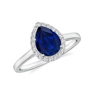 Könnte beinhalten: Ein Ring mit einem birnenförmigen Saphir, der von einem Heiligenschein aus kleineren Diamanten umgeben ist, in einer silbernen Fassung.