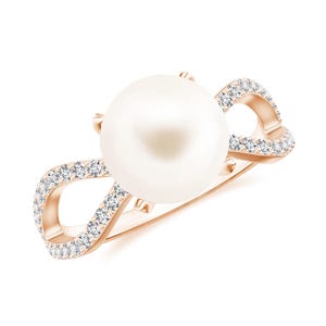 May include: A rose gold ring with a large white pearl set in the center. The ring band is adorned with a row of small diamonds.