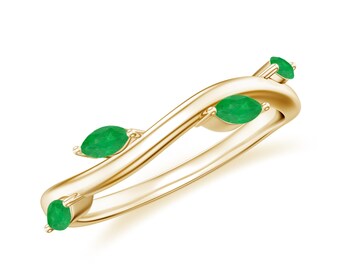 May include: A gold band ring with a wavy design and four emerald green marquise-shaped gemstones.