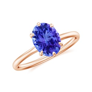 以下が含まれることがあります： 大きな楕円形の青い宝石が付いたローズゴールドのリングです。