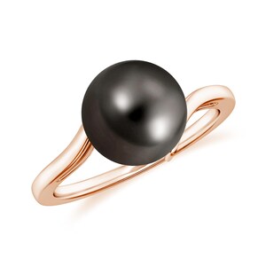 Pode incluir: Um anel de ouro rosa com uma grande pérola preta. O anel tem um design simples e elegante.
