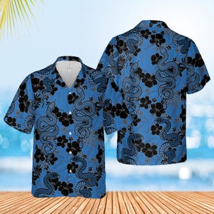 May include: A blue short-sleeved button-down shirt with a black and white snake and flower pattern.