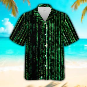 May include: Black short-sleeved shirt with a green digital rain design. The shirt has a classic collar and button-up front. The design is a repeating pattern of green characters on a black background, resembling computer code.