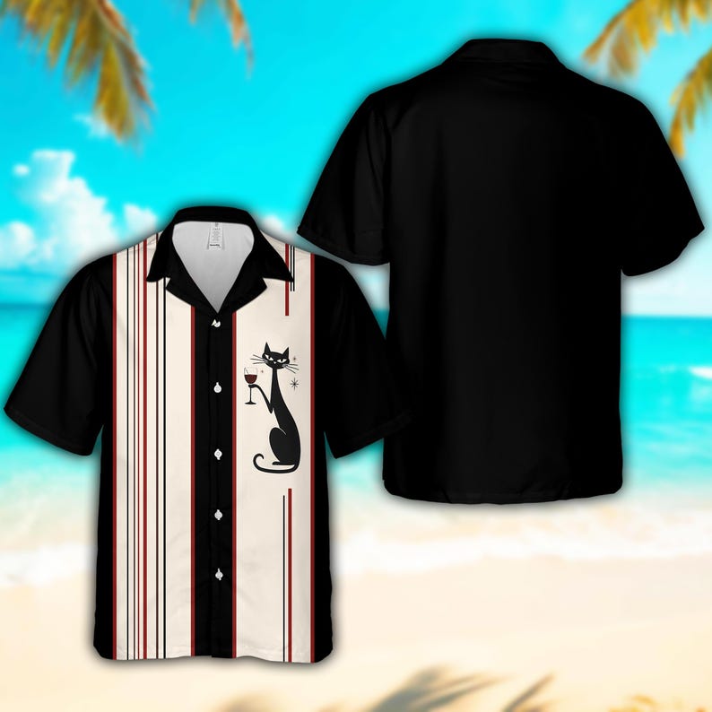 May include: A black short-sleeve button-down shirt featuring a white vertical panel on the front. The panel displays a black cat illustration holding a glass of red wine, accented by thin red and black vertical stripes and small starburst details.