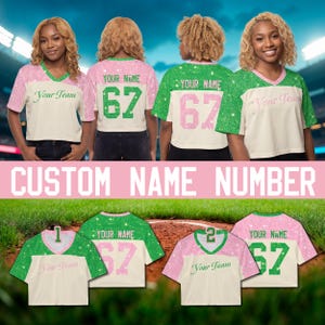 May include: A collection of custom cropped jerseys featuring a V-neck design with green and pink glittery accents. The shirts display the text Your Team, Your Name, and the number 67 in various color combinations on a cream-colored base fabric.