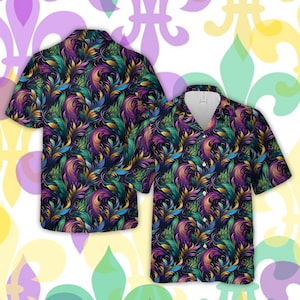 May include: Two short-sleeved button-up shirts with a colorful floral pattern. The pattern features gold, purple, green, and blue colors on a dark background.
